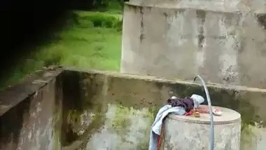 Indian village girl bathing near water tank outdoor