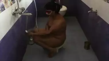 Fat Indian female with a mask on her face performs porn showering